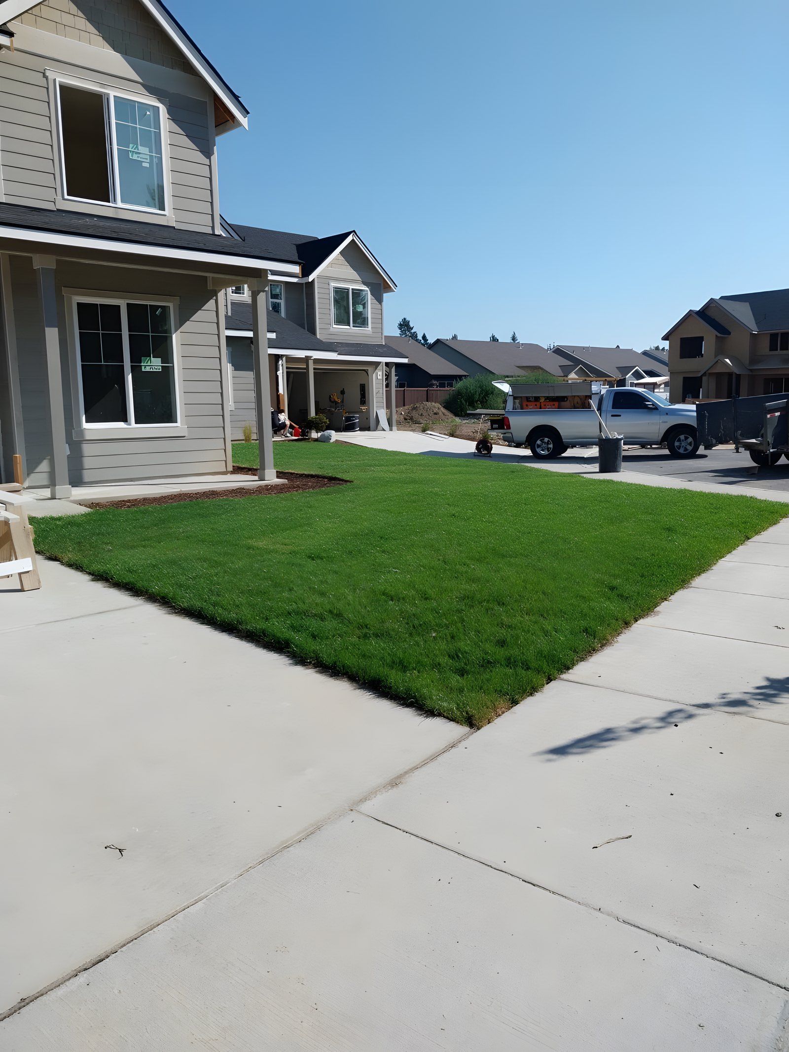 New sod lawn between a sidewalk and driveway on a corner lot