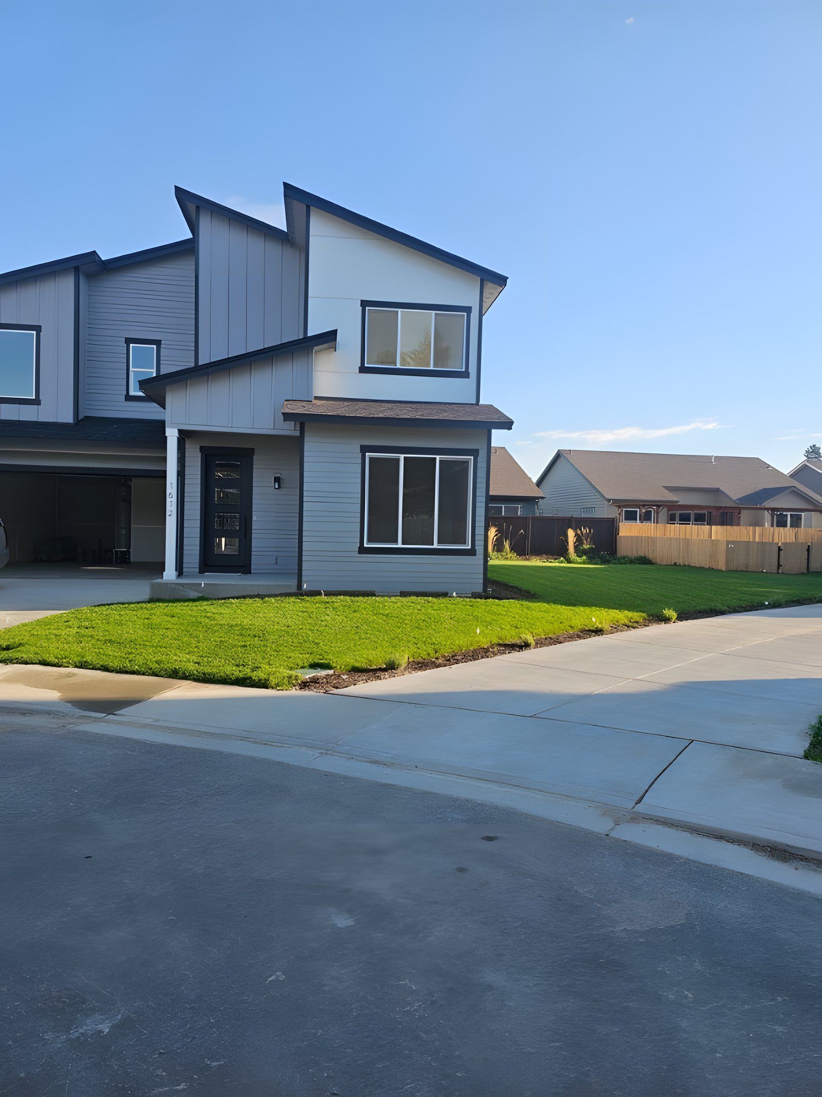 New sod lawn in front of a modern two-story house at the end of a cul-de-sac