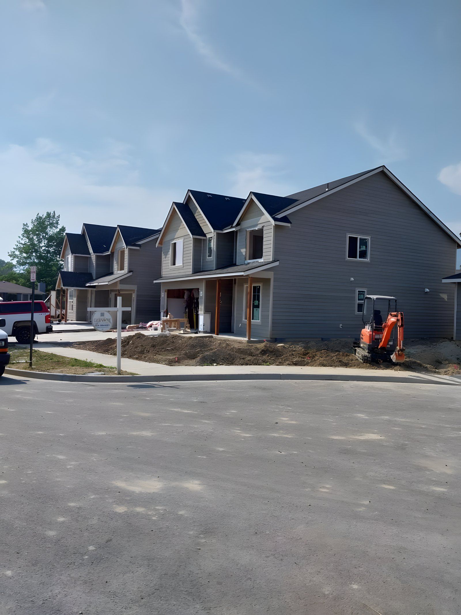 Mini excavator grading the front yard of a new two-story house